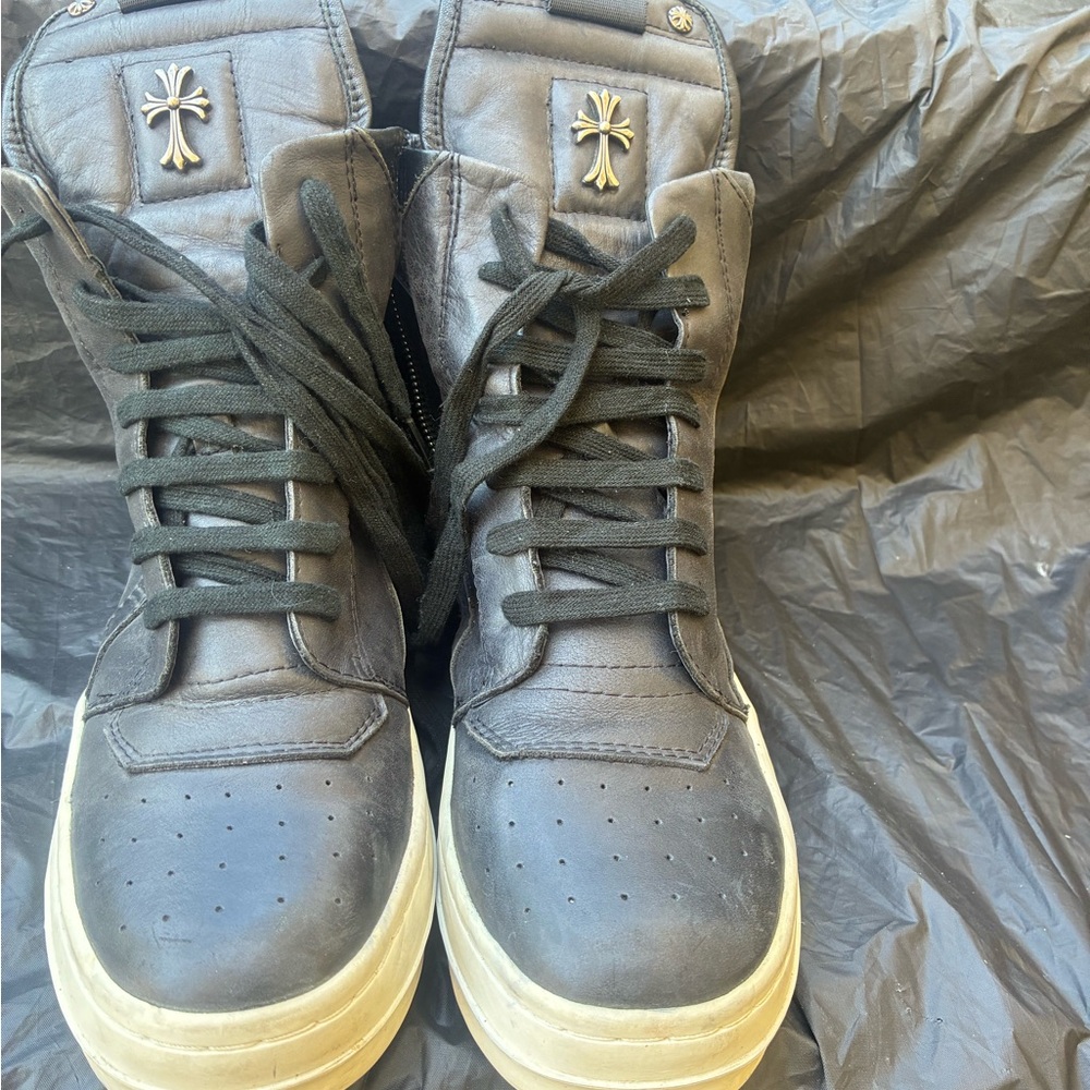 Black High-Top Sneakers with Cross Accent resemble Rick Owens x Chrome Heart.